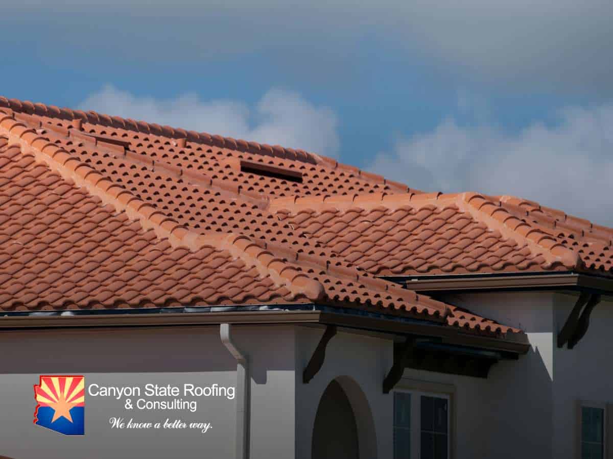 Close-up of a home with a red clay tile roof, highlighting its structure and weather exposure