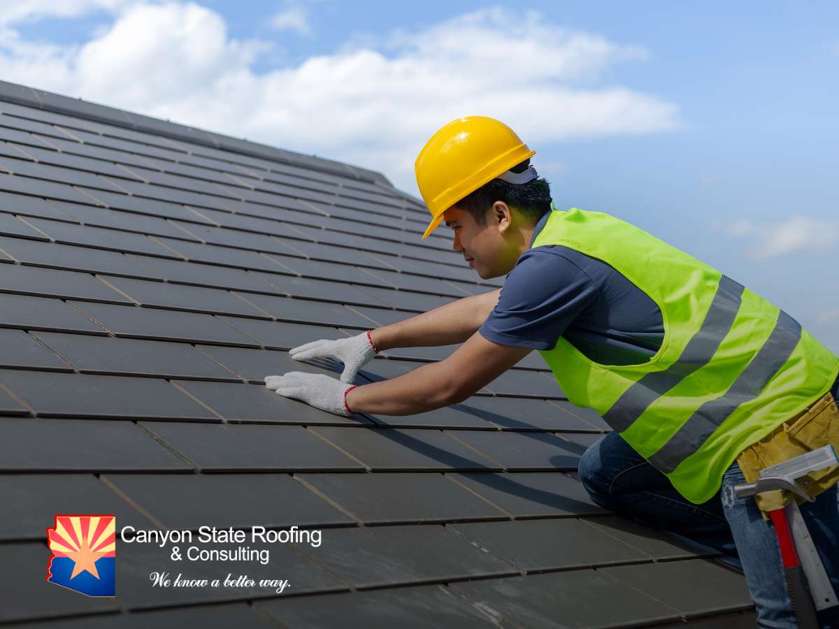 Worker performing roof replacement on a tile roof.