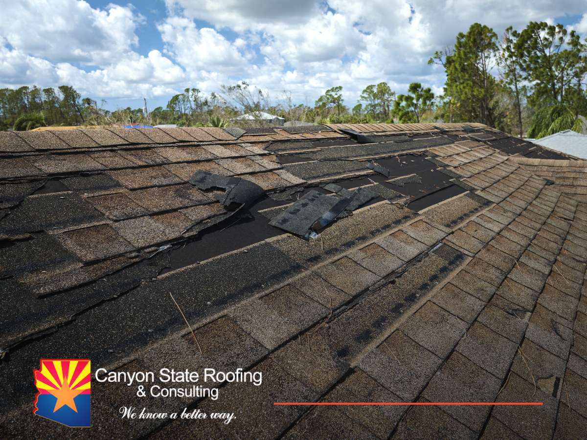 Damaged house roof with missing shingles in Arizona